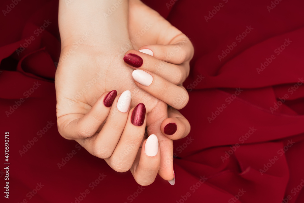 Premium Photo | Hands of a young woman with dark red manicure on nails