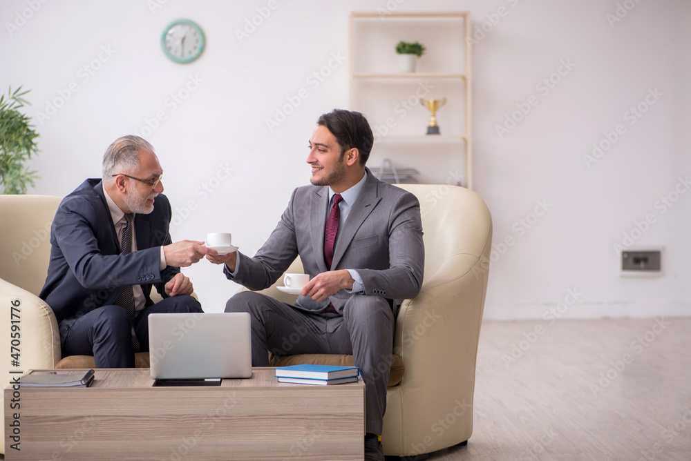 Two businessmen discussing project at workplace Two businessmen discussing project at workplace