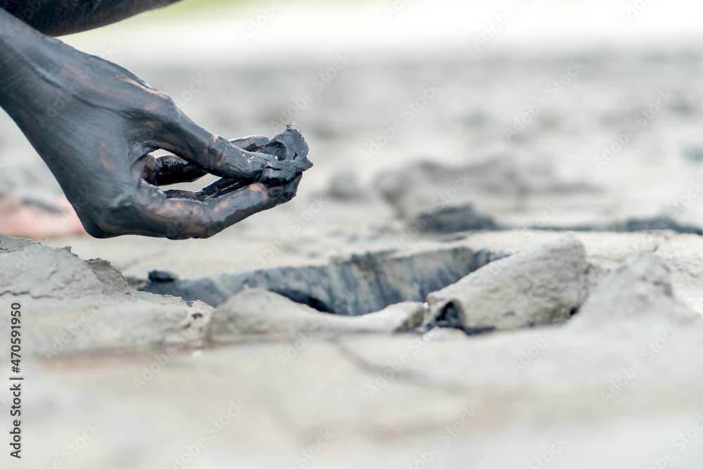 Hand with mineral mud from a pit for cosmetic and medical procedures ...