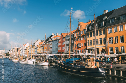 Boats moored at harbor on sunny day, Nyhavn, Copenhagen, Denmark photo