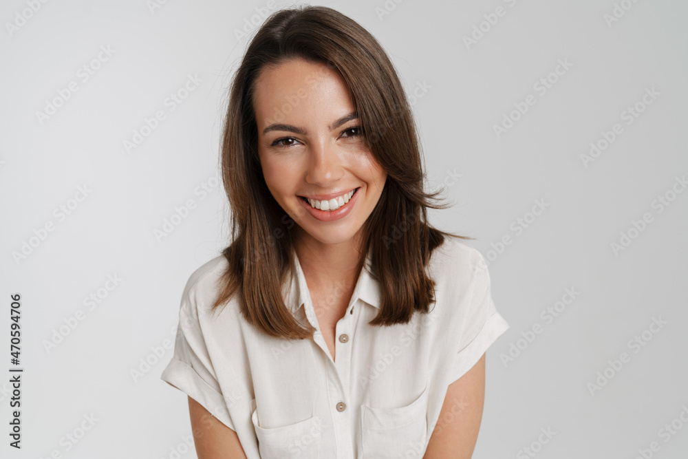 Young european woman in shirt smiling and looking at camera Young european woman in shirt smiling and looking at camera