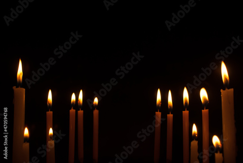 Group of candles with beautiful bright yellow golden flames on black background. Ideas for Halloween, Christmas, Home, Romance, Love, Copy space for you
