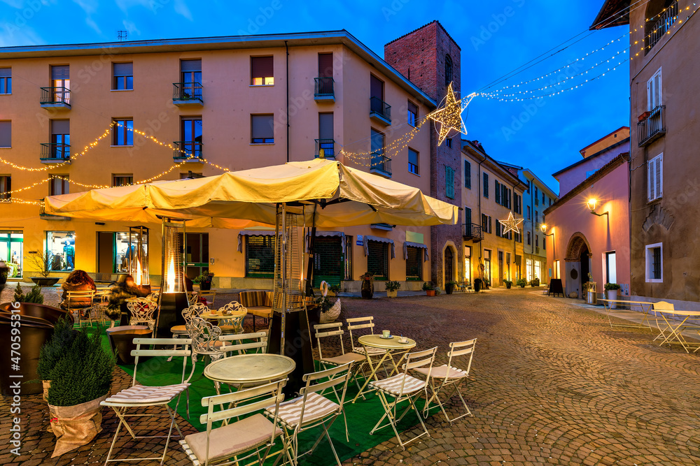 Outdoor restaurant on small town square in the evening in Alba, Italy.