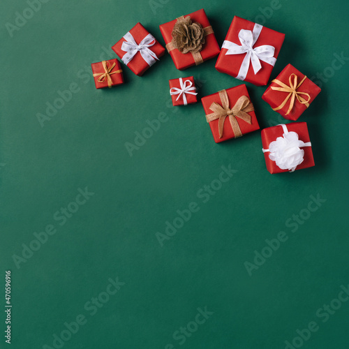 Gift boxes with white and brown bows on a green backdrop. © Anna