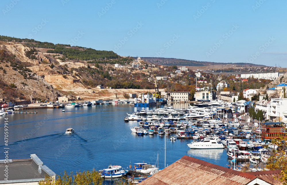 Crimea. Top view of Balaklava town, Balaklava bay with port and many boats, yachts and ships on the pier on a sunny autumn day. Traveling on the Crimean Peninsula