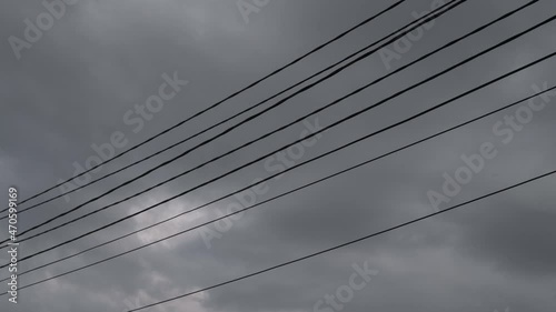 Wires against the sky are swaying from the wind.