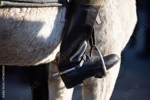 A military boot in the stirrup against the horse's belly vindicates the white. photo