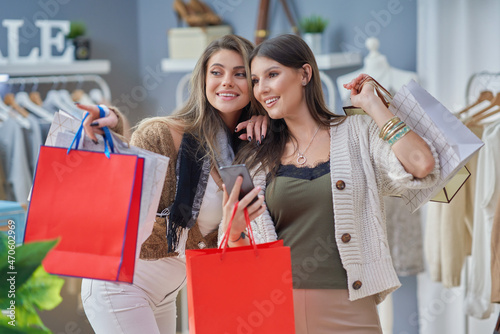 Group of happy friends during shopping with phone