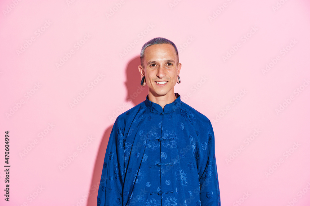 Fototapeta premium Young white man in chinese jacket smiling and looking at camera