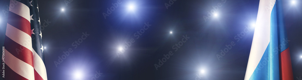 Banner, flag of the United States of America and the Russian Federation on a dark background in the light of camera flashes.