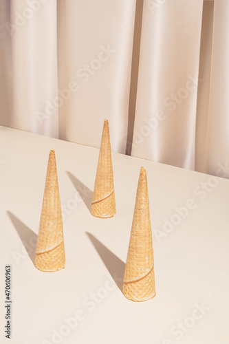 Minimal modern summer composition with three ice cream cones on stylish silk background. Trendy retro concept.