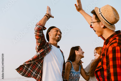 Foto Young multiracial friends making fun while giving high five