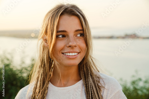 White young woman with pigtails smiling and looking aside