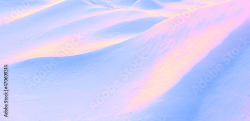 Abstract surreal image in neon pink, blue and golden colors undulating slopes of snow drifts. photo