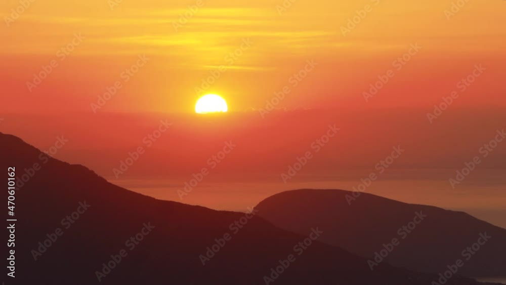 The big sun sunset mediterranean landscape of sea, mountains and clouds. The big sun sunset mediterranean landscape of sea, mountains and clouds.