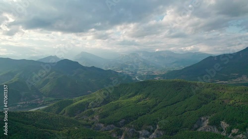 A great mountain, a rock protruding on a plateau in the Pyrenees mountains. Spectacular view of the mountain range from a drone with huge cumulus clouds in the background.