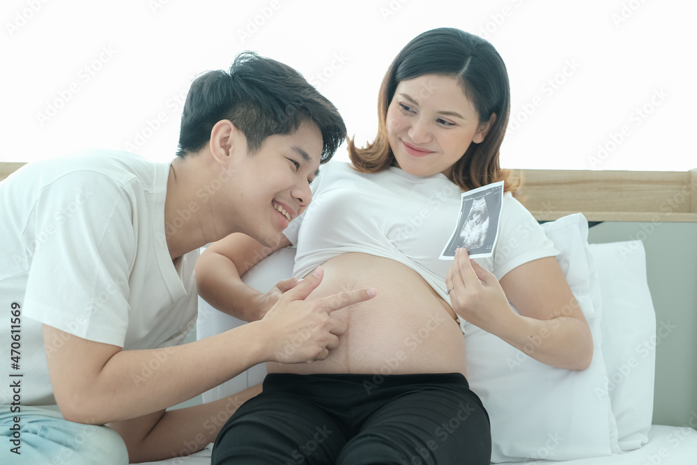 portrait asia young pregnant woman and husband happy together on the bed portrait asia young pregnant woman and husband happy together on the bed
