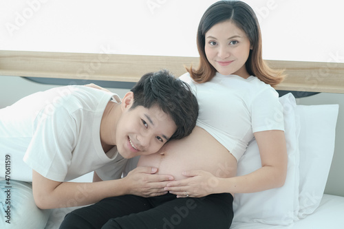 portrait asia young pregnant woman and husband happy together on the bed