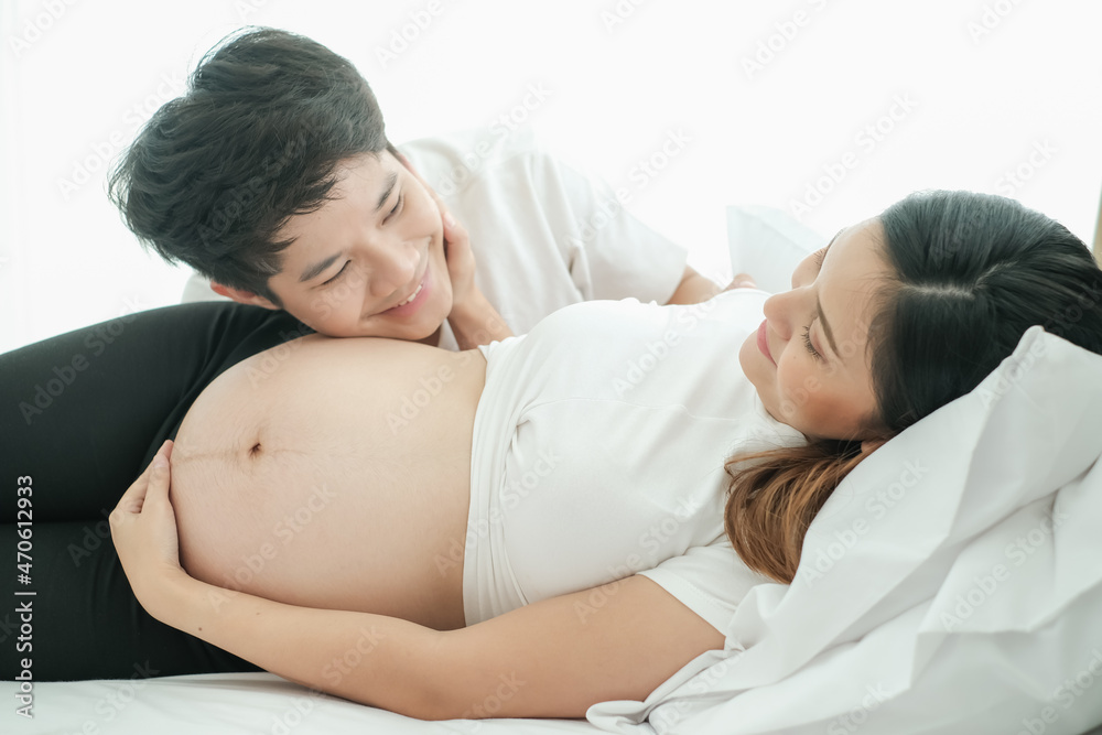 portrait asia young pregnant woman and husband happy together on the bed portrait asia young pregnant woman and husband happy together on the bed