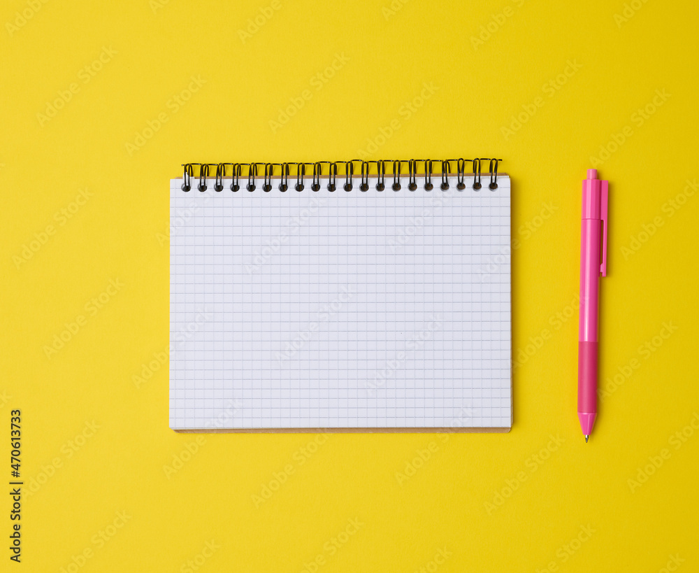 open notebook in a cage with white blank sheet and on a yellow background, top view open notebook in a cage with white blank sheet and on a yellow background, top view