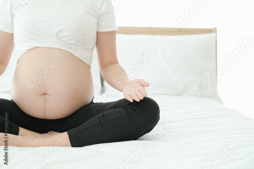 pregnant playing yoga poses on the bed