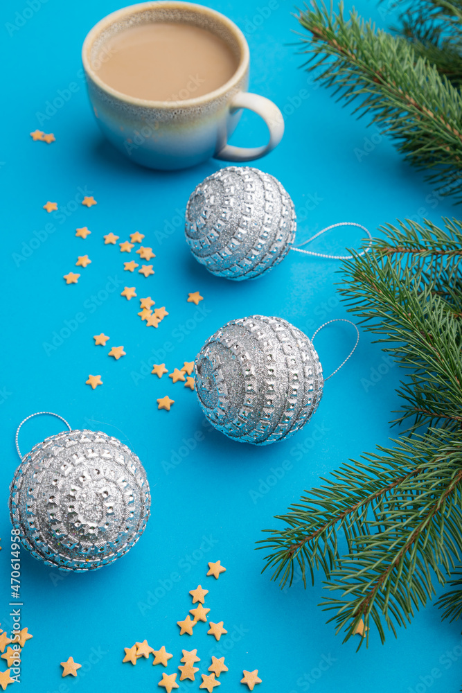 Christmas or New Year composition. Decorations, silver balls, fir and spruce branches, on a blue background. Side view, close up. Christmas or New Year composition. Decorations, silver balls, fir and spruce branches, on a blue background. Side view, close up.