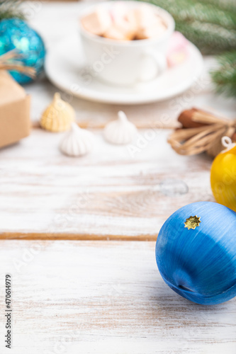 Christmas or New Year frame composition. Decorations, box, balls, fir and spruce branches, cup of coffee, on a white wooden background. Side view, copy space.