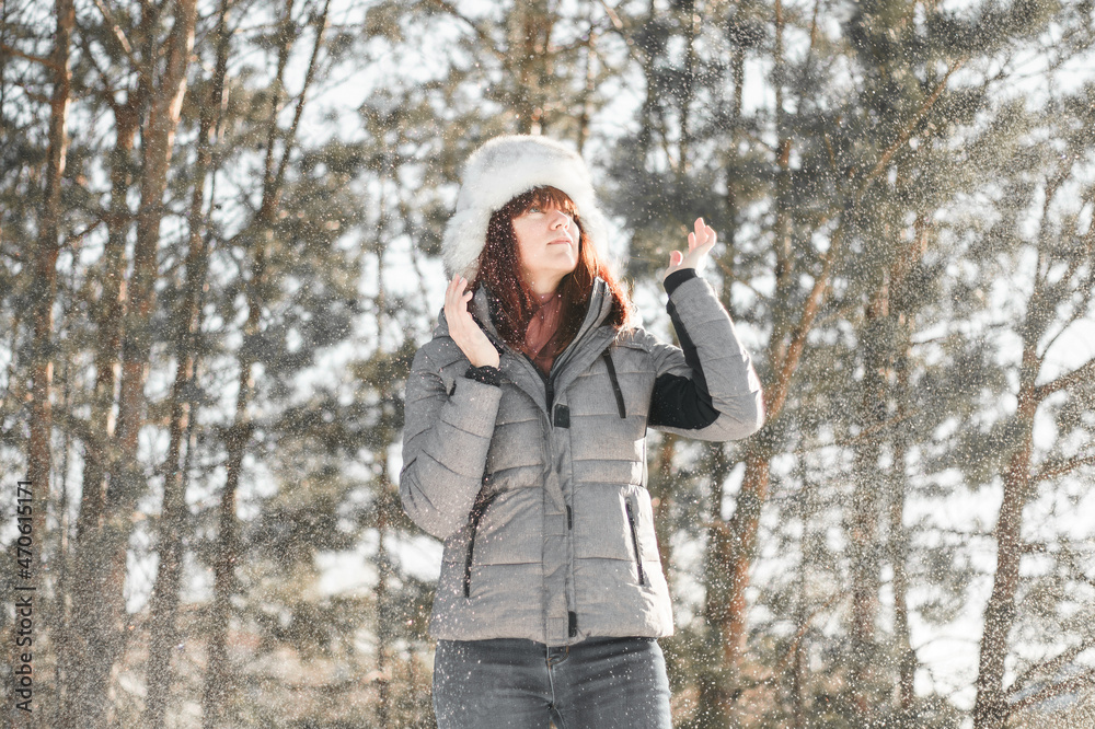 Winter fun. Woman plays throwing snow with arms up open in freedom enjoying cold season. Happy and joyful concept. Winter fun. Woman plays throwing snow with arms up open in freedom enjoying cold season. Happy and joyful concept.