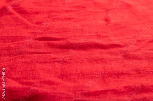 Fragment of smooth red linen tissue. Top view, natural textile background.