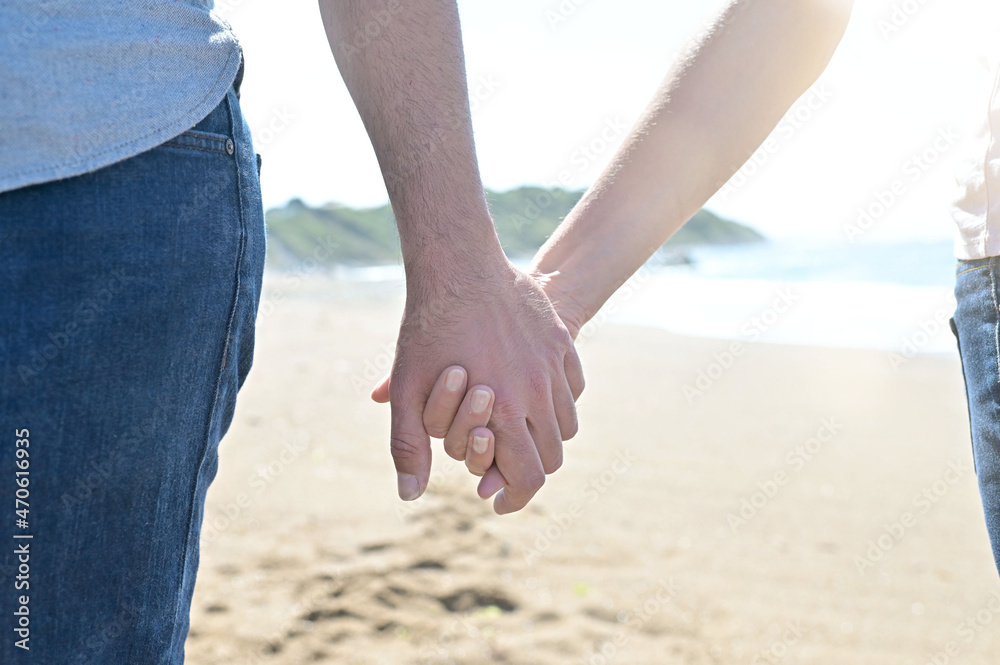 Middle-aged couple walking on a sandy beach Middle-aged couple walking on a sandy beach