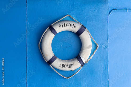 Cuadro en lienzo Lifebuoy with Welcome aboard phrase hang on blue concrete background