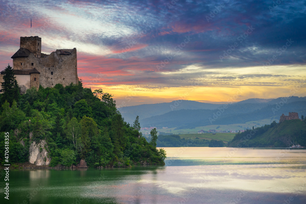 Medieval Dunajec Castle in Niedzica with a reflection in the Czorsztyn Lake at sunset. Poland