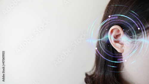 Ear of young woman with sound waves simulation technology. Concept of hearing test, hearing aids, ear disorders and health care. photo