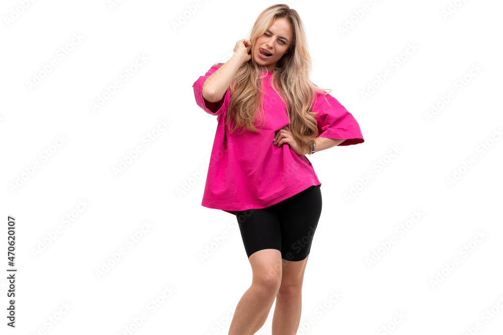 a woman in black shorts and a pink t-shirt is dancing on the background coquettishly sticking out her tongue a woman in black shorts and a pink t-shirt is dancing on the background coquettishly sticking out her tongue
