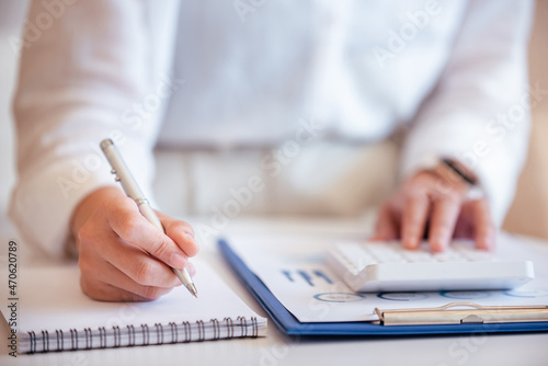 A young woman's hand presses a calculator to determine and summarize the cost of mortgage home loans for refinancing plans, lifestyle concepts.