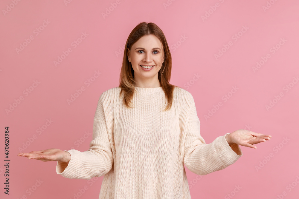 Portrait of positive kind blond woman standing with open empty hands, glad to share, giving everything she has, wearing white sweater. Indoor studio shot isolated on pink background. Portrait of positive kind blond woman standing with open empty hands, glad to share, giving everything she has, wearing white sweater. Indoor studio shot isolated on pink background.