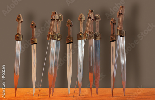 Group of shiny daggers with wooden handles photo