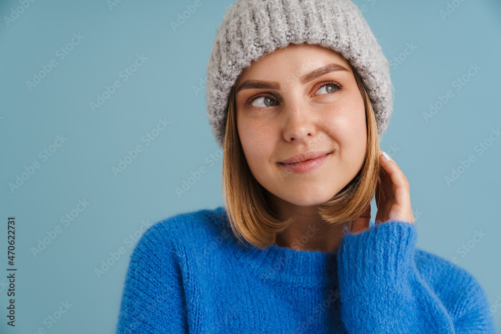 Young blonde woman wearing knit hat smiling at camera Young blonde woman wearing knit hat smiling at camera