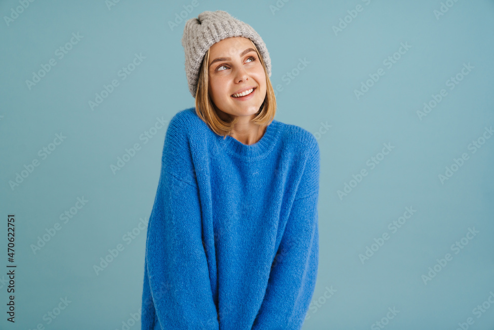 Young blonde woman wearing knit hat smiling at camera Young blonde woman wearing knit hat smiling at camera