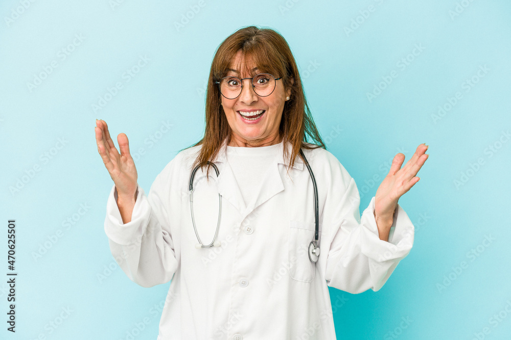 Middle age doctor woman isolated on pink background receiving a pleasant surprise, excited and raising hands. Middle age doctor woman isolated on pink background receiving a pleasant surprise, excited and raising hands.