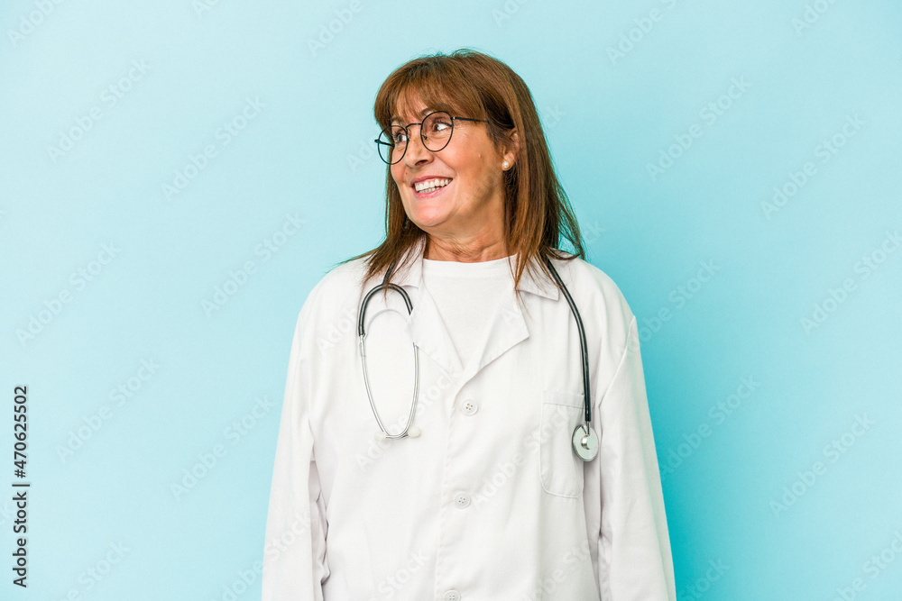 Middle age doctor woman isolated on pink background looks aside smiling, cheerful and pleasant. Middle age doctor woman isolated on pink background looks aside smiling, cheerful and pleasant.