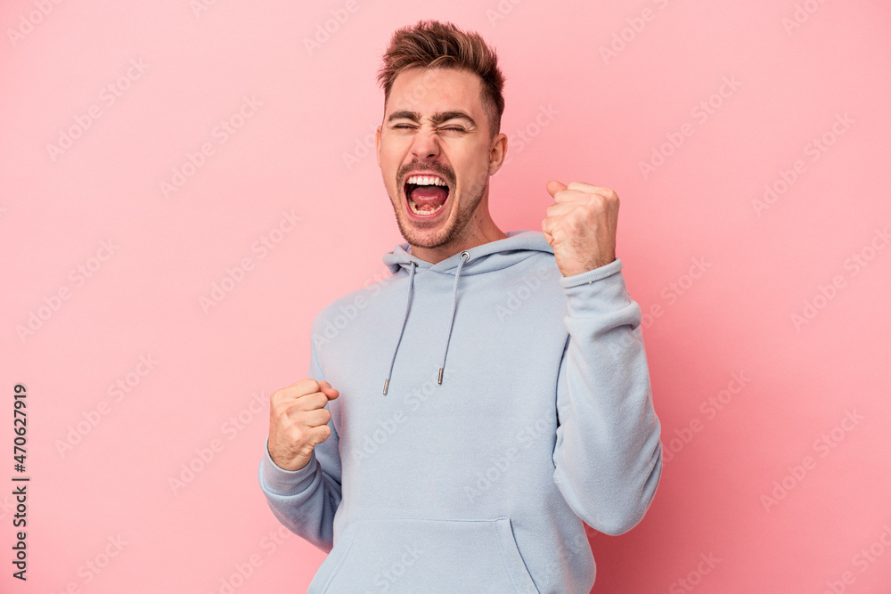 Young caucasian man isolated on pink background cheering carefree and excited. Victory concept. Young caucasian man isolated on pink background cheering carefree and excited. Victory concept.