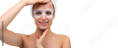 middle-aged woman with a smile on her face in a cosmetic mask around the eyes looks at the camera, the concept of skin care and skin rejuvenation procedures