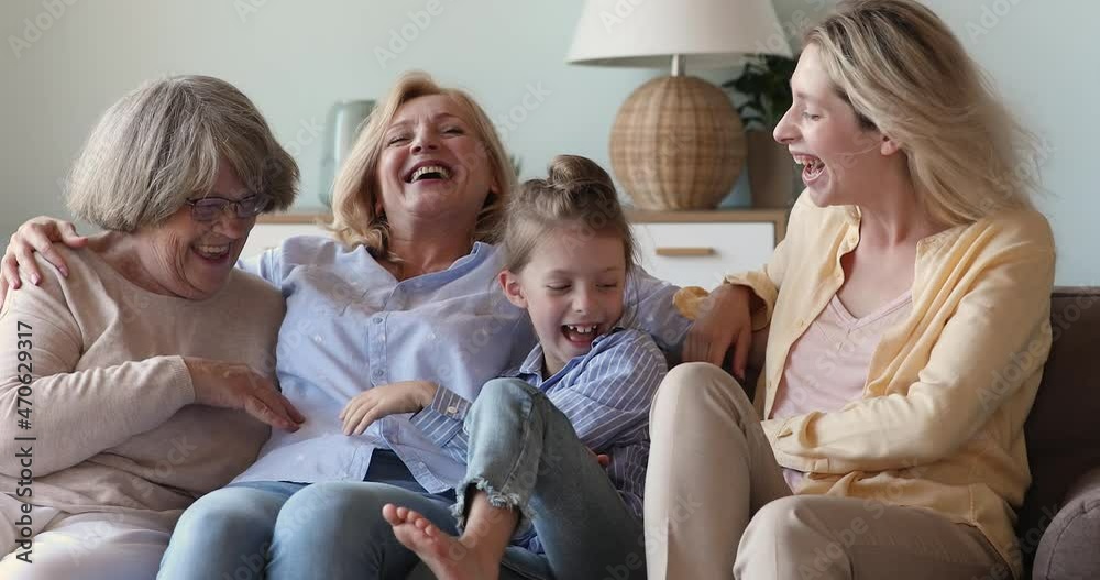 Overjoyed intergenerational family senior great grandma older grandmother grown mother small daughter tickle laugh play on sofa. Cute happy females relatives of diverse age having fun messing at home Overjoyed intergenerational family senior great grandma older grandmother grown mother small daughter tickle laugh play on sofa. Cute happy females relatives of diverse age having fun messing at home
