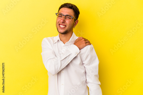 Young caucasian man with tattoos isolated on yellow background having a shoulder pain.