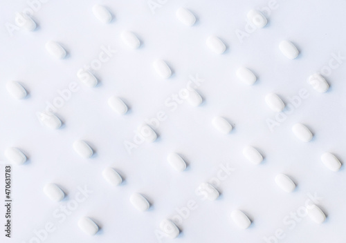 White pills on a white background. Oblong and round pills close-up. Healthcare and medicine. © Olena Svechkova