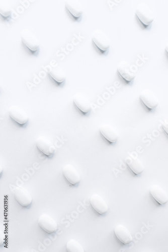White pills on a white background. Oblong and round pills close-up. Healthcare and medicine. 