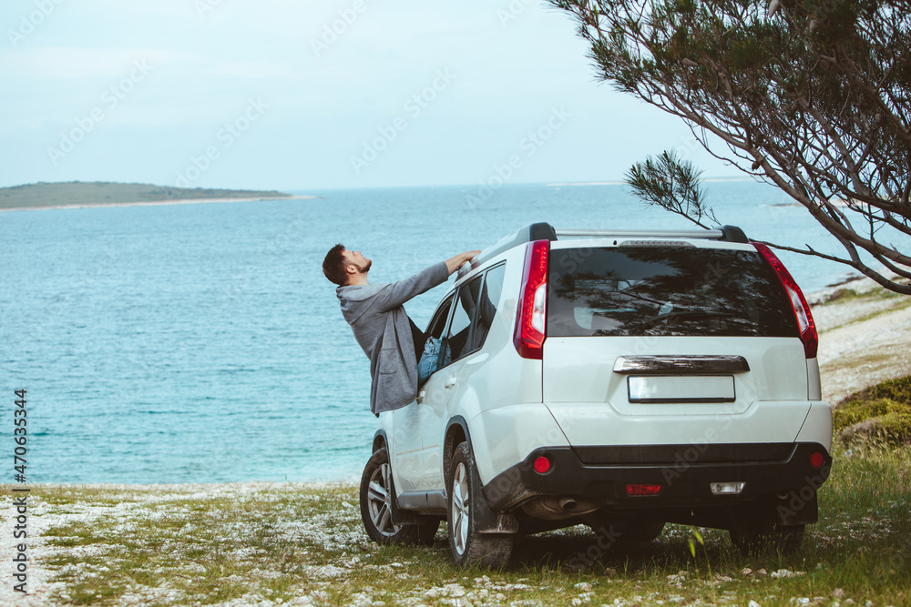smiling man stick out from car window. summer sea on background smiling man stick out from car window. summer sea on background