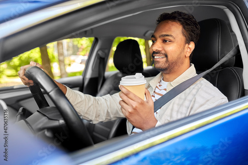 transport, vehicle and people concept - happy smiling indian man or driver with takeaway coffee cup driving car