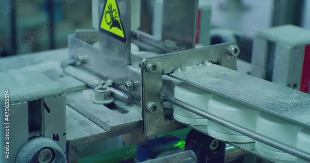 modern production. caps for plastic vials move on a conveyor. close-up of a technological process. modern production. caps for plastic vials move on a conveyor. close-up of a technological process.
